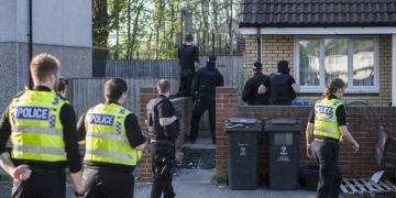 Armed police swarm Swindon street as police helicopter hovers overhead