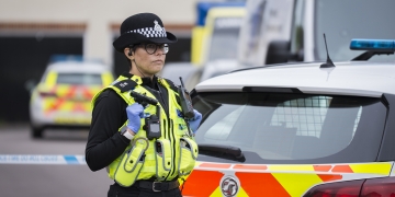 Road cordoned off as crime scene as detectives investigate death of woman