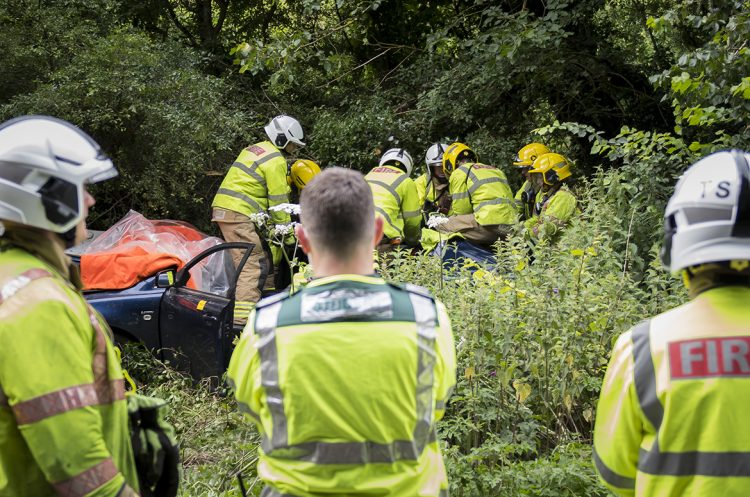 Firefighters work to free casualty from wreckage after undergrowth crash