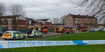 Police close road as a dozen firefighters battle serious flat blaze in Swindon