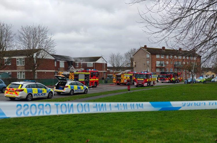 Police close road as a dozen firefighters battle serious flat blaze in Swindon