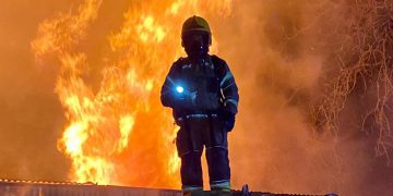 Road closed as dozens of firefighters battle major blaze at timber yard