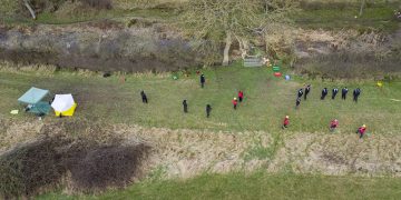 Specialist police officers and search volunteers line former canal