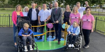 Justin Tomlinson cuts ribbon on inclusive roundabout installed in Swindon play area