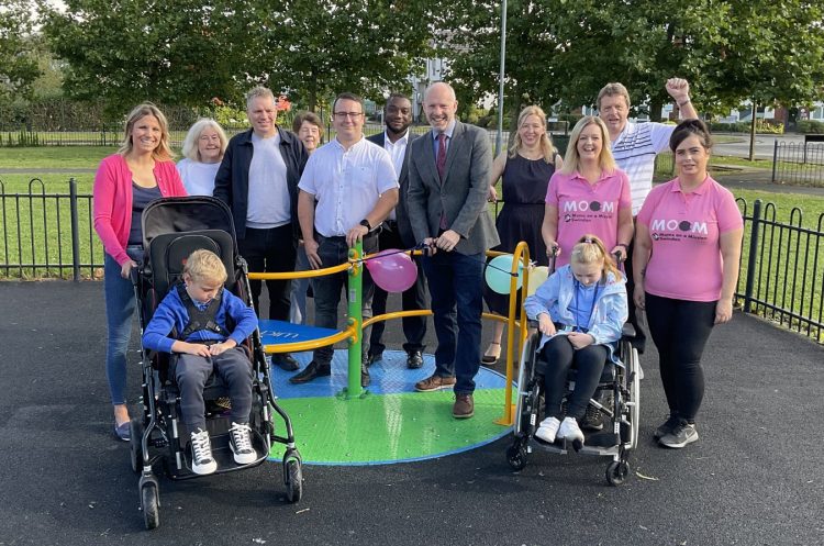 Justin Tomlinson cuts ribbon on inclusive roundabout installed in Swindon play area