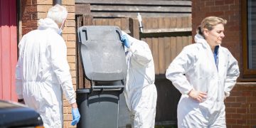 Man remains in custody on suspicion of woman’s murder as forensics search cars and bins