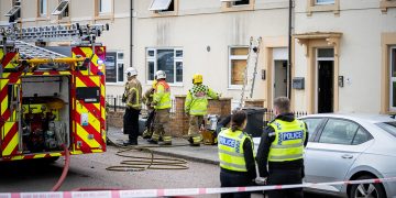 Firefighters tackle blaze at Swindon B&B as police close central route