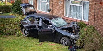 BMW driver smashes car through phone box and into building