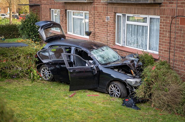 BMW driver smashes car through phone box and into building