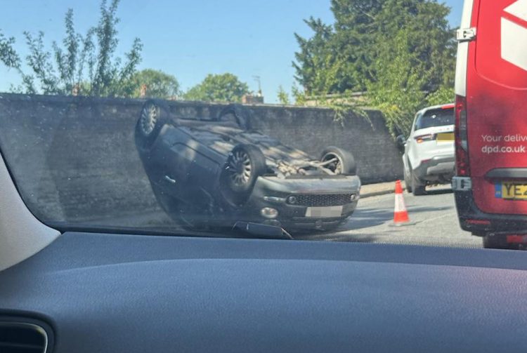 Car crashes and overturns on road near Wilton shopping village