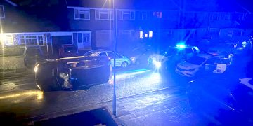 BMW overturns in residential street during armed police chase