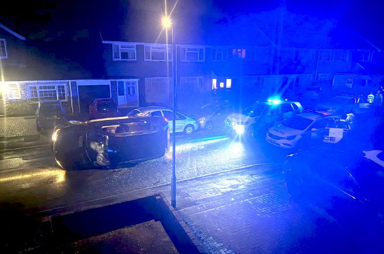 BMW overturns in residential street during armed police chase