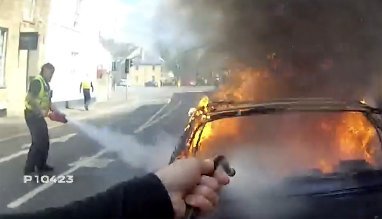 Police officers tackle raging car blaze using only fire extinguishers
