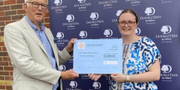A man presenting a giant cheque to a woman
