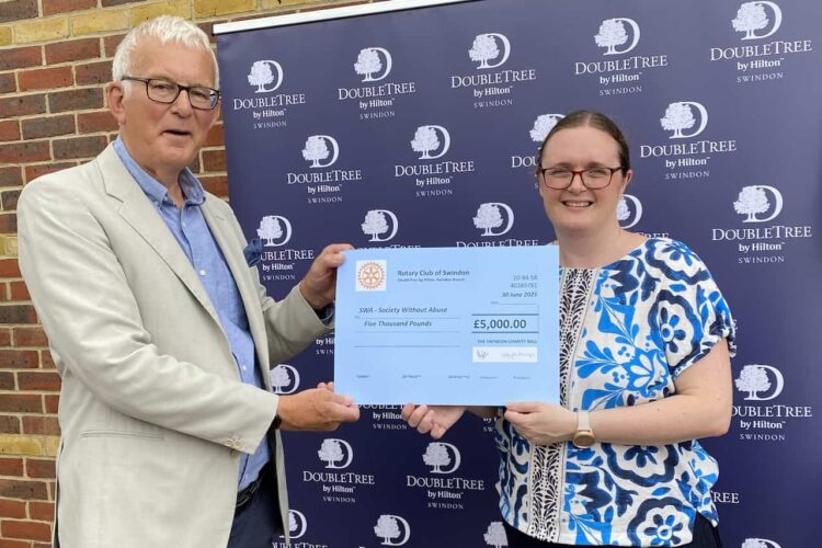 A man presenting a giant cheque to a woman