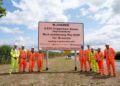 A group of people in hi-viz clothing and hard hats. In between them is a sign that reads MJ Church A 350 Chippenham Bypass Improvements Work commencing May 2025 For 18 months Working in partnership with Wiltshire Council, Department for Transport, Atkins Realis and then the web address wiltshire.gov.uk/highways-improvements