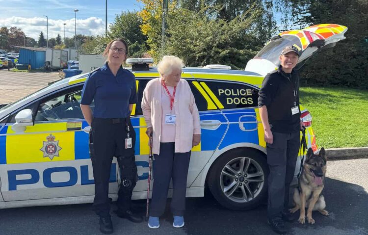 Hazel Bush with police officers next to a patrol car