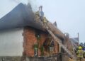 Firefighters scale ladder to attack thatch blaze in Wiltshire village