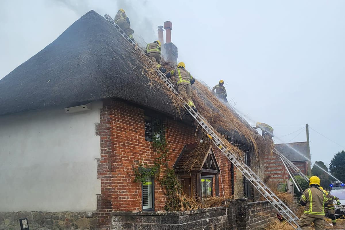 Firefighters Scale Ladder To Attack Thatch Blaze In Wiltshire Village firefighters-scale-ladder-to-attack-thatch-blaze-in-wiltshire-village